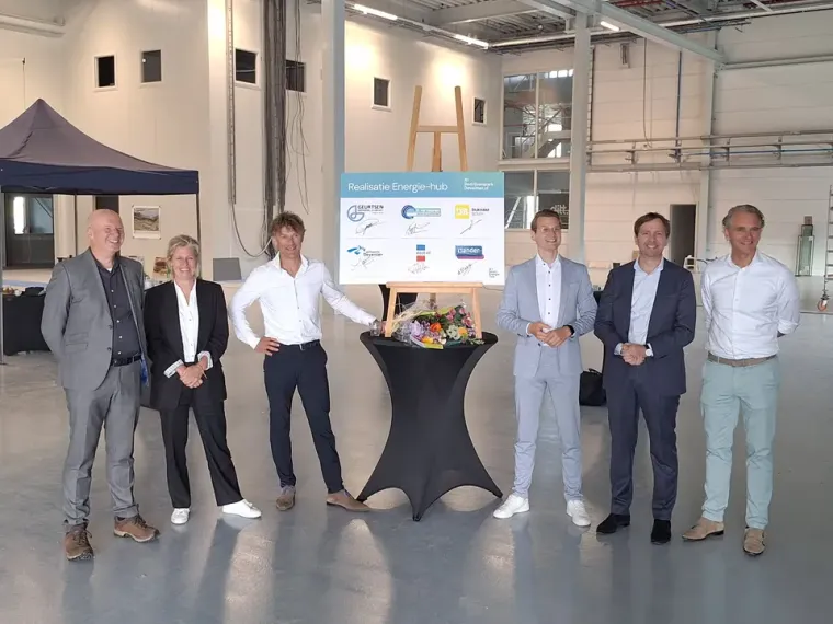 Ondertekening van de energiehub op A1 Bedrijvenpark Deventer: zes betrokkenen rond het ondertekende bord op een ezel